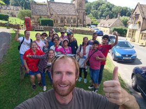 Tom doing thumbs up to the camera with happy guests behind him